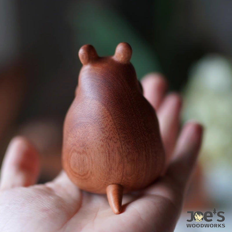 Back view of wooden mouse showing curved tail and smooth wood finish.
