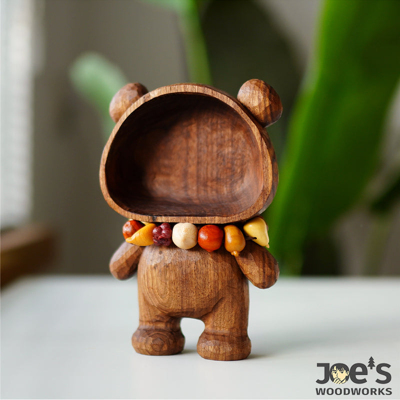 Bear scoop standing upright with colorful fruit charm bracelet resting on its neck