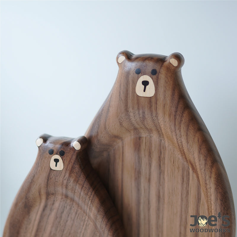Close-up of hand-carved bear faces on walnut wood trays – cute and smooth finish