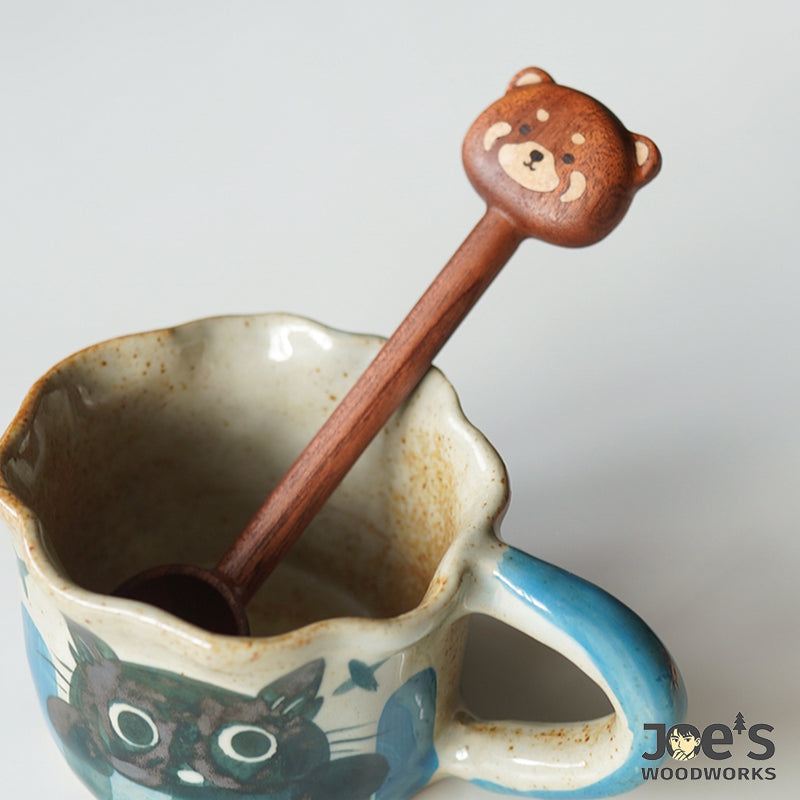Wooden bear scoop resting inside a ceramic mug, ideal for sugar, tea, or coffee.