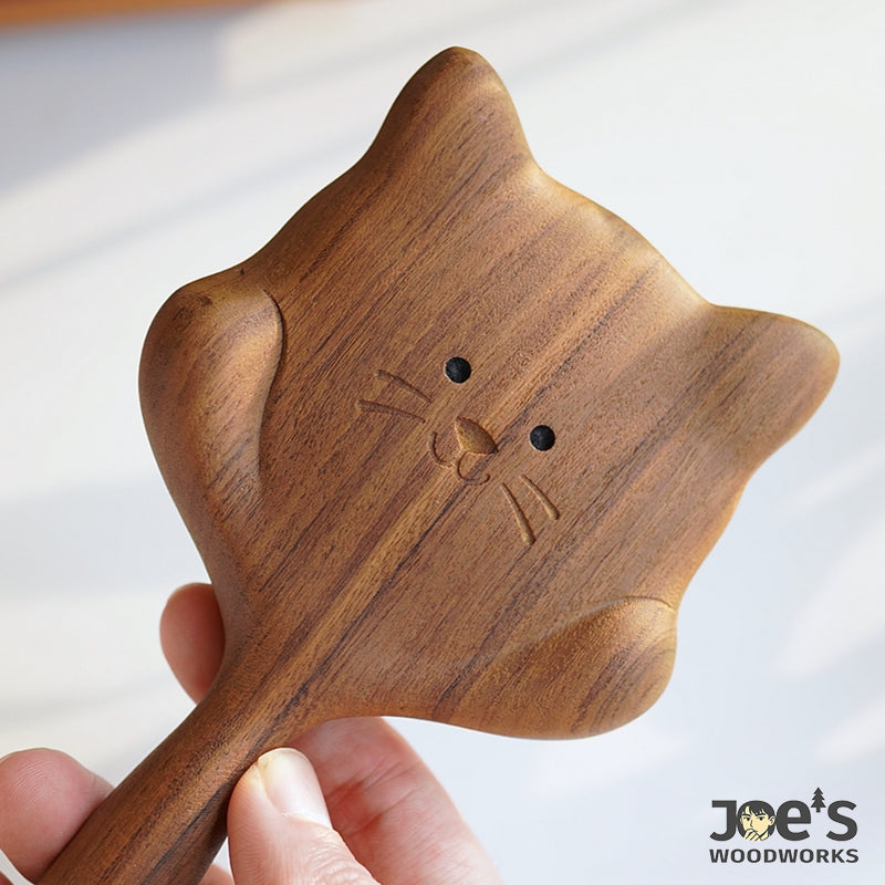 Close-up of cute engraved cat face on wooden massage hair brush