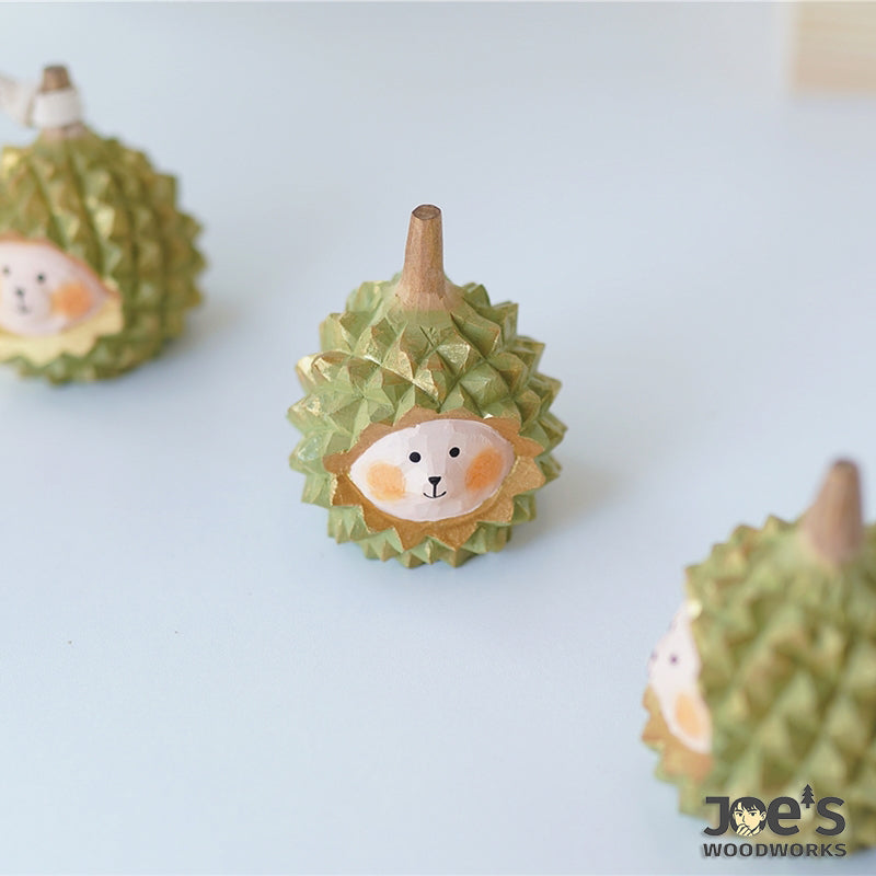 Set of cute durian-shaped animal wood figurines on light background