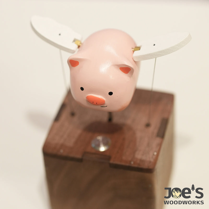 Top angle view of the kinetic pig sculpture showing wing movement