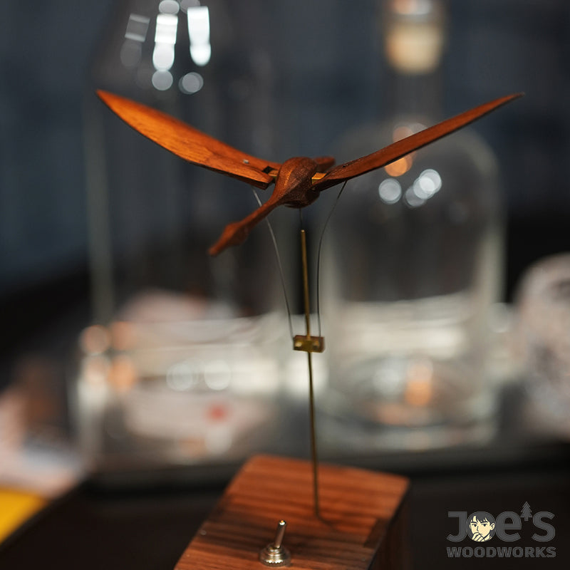 Dark brown wooden swan automaton under ambient lighting