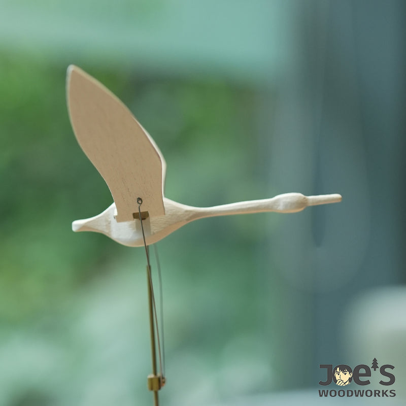 Close-up of white wood swan with brass mechanism