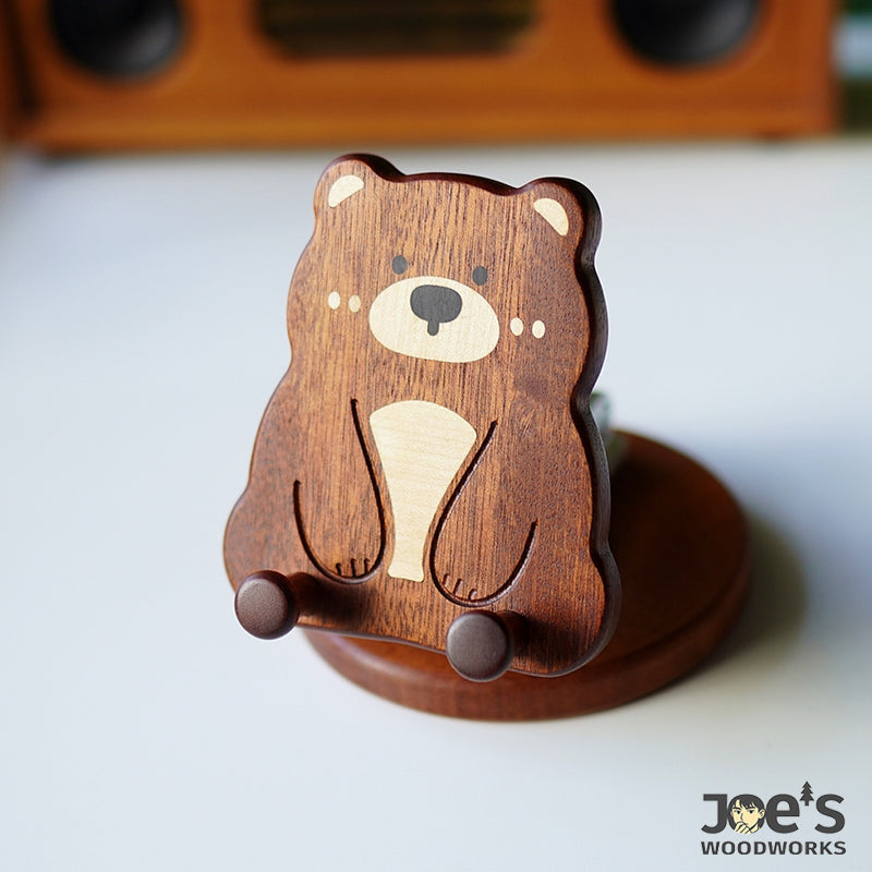 Front view of hand-carved wooden bear phone holder with stable support