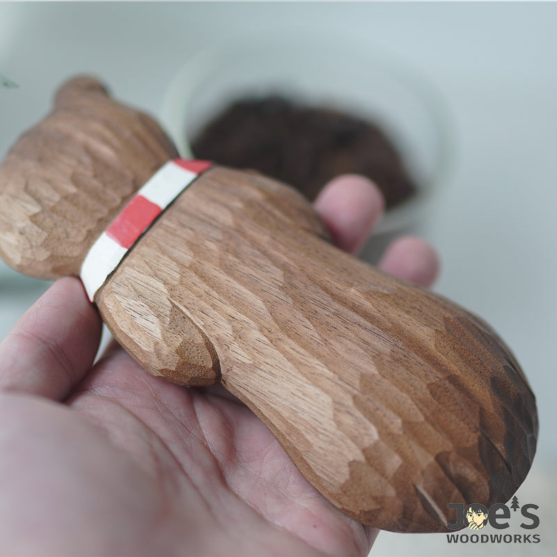 Close-up of hand-carved texture on the back of the wooden bear scoop.