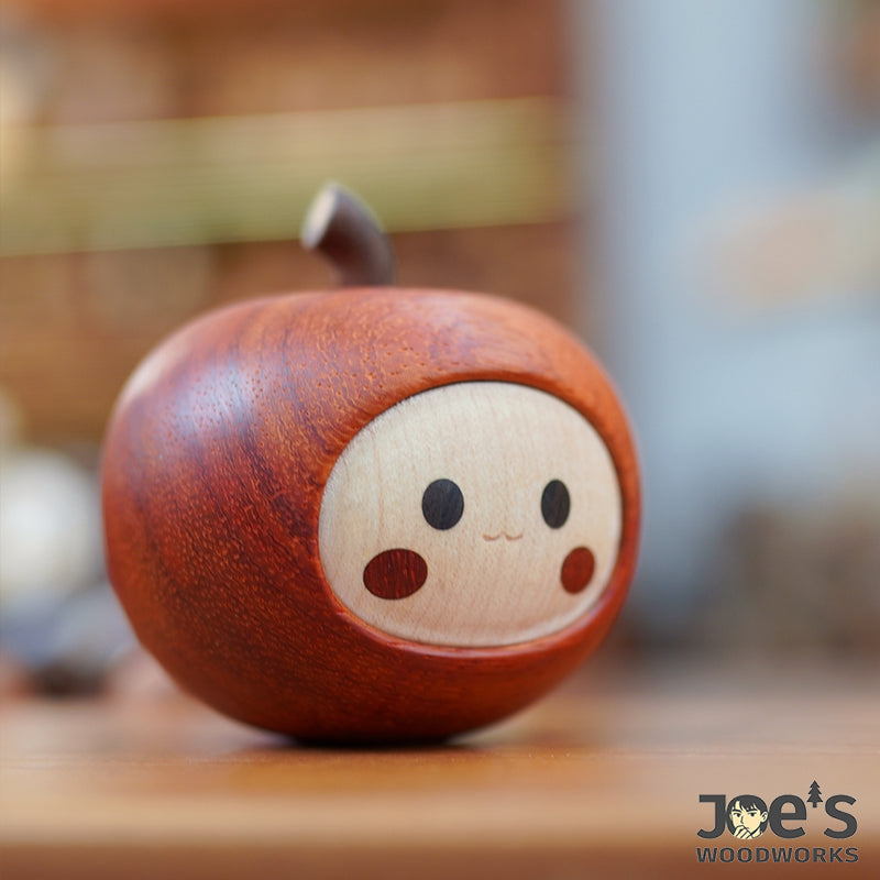 Side angle of handcrafted wooden apple figurine on tabletop