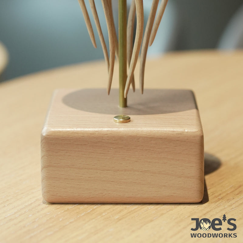 Close-up of brass push button on the beech wood base