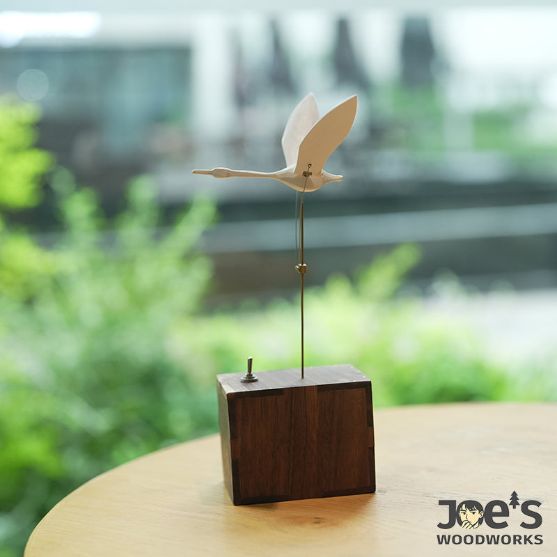 Side view of kinetic swan automaton with walnut wood base