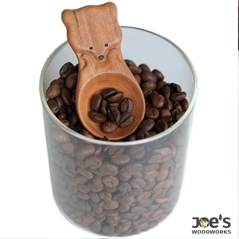 Cute fox coffee scoop made of light wood in a full jar of roasted beans