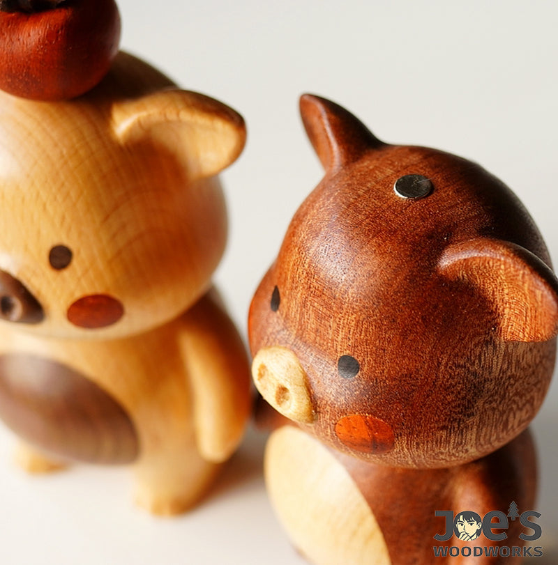 Close-up of handcrafted pig wood figurines showing magnetic top and detail
