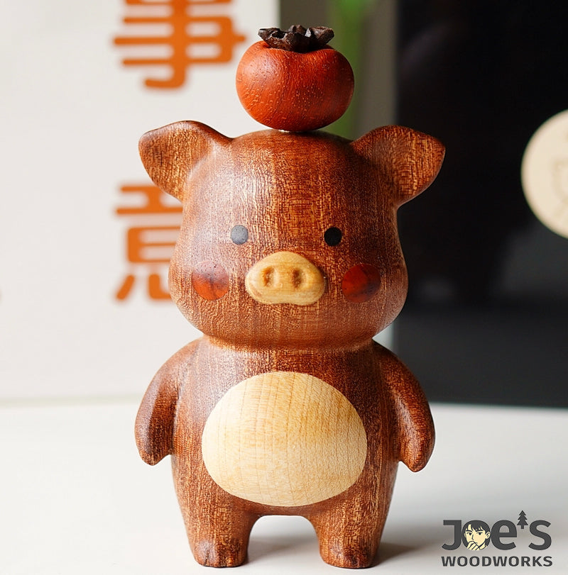 Hand-carved dark wood pig figurine with persimmon fruit on top, artisan home decor