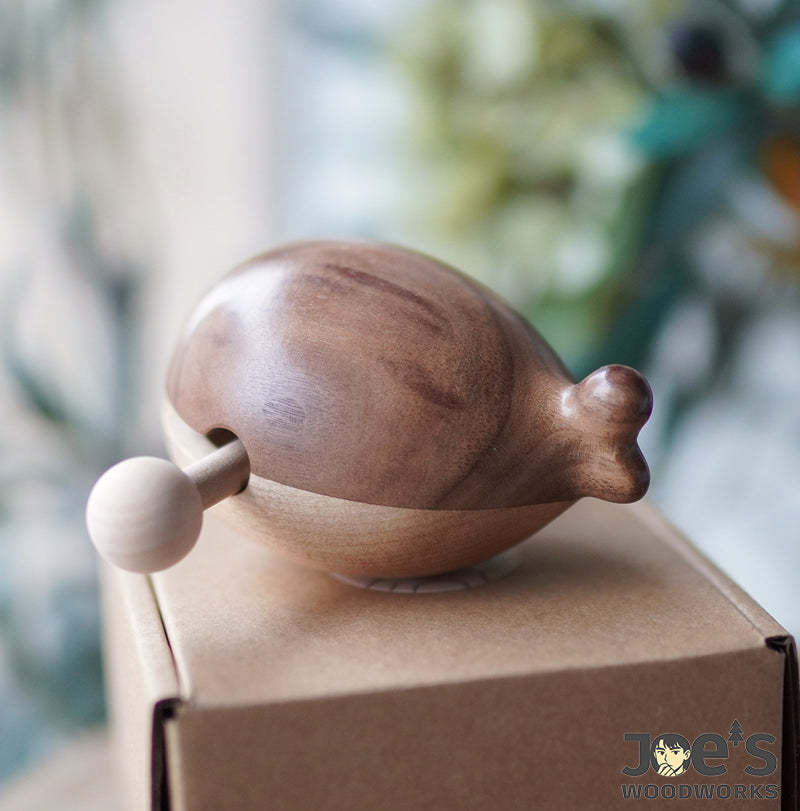 Back view of the Mini Whale Wooden Knock Toy showing smooth walnut grain and tail detail