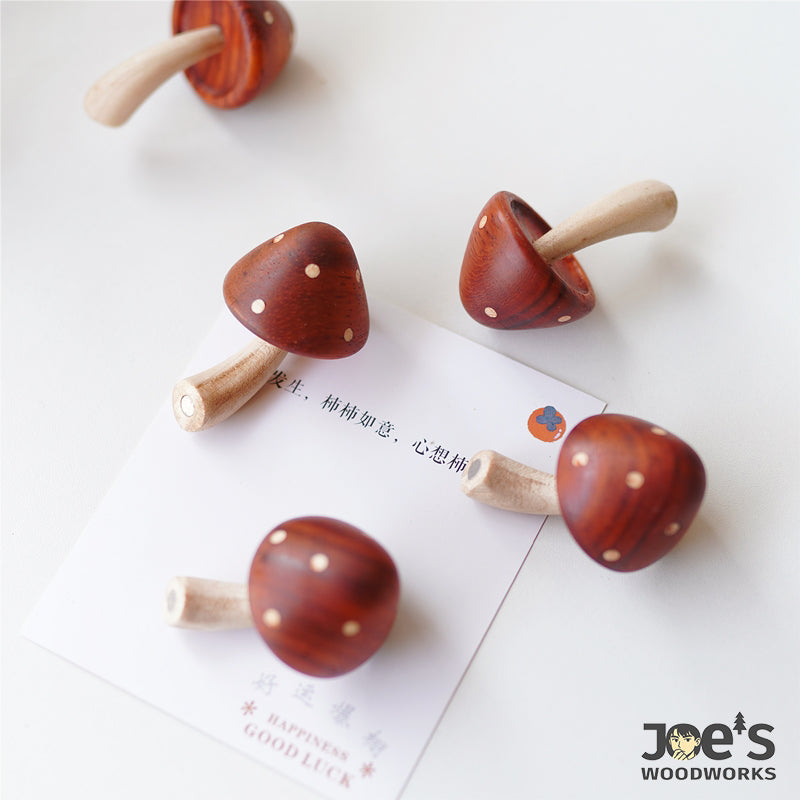 Top view of multiple wooden mushroom magnets with gift card background