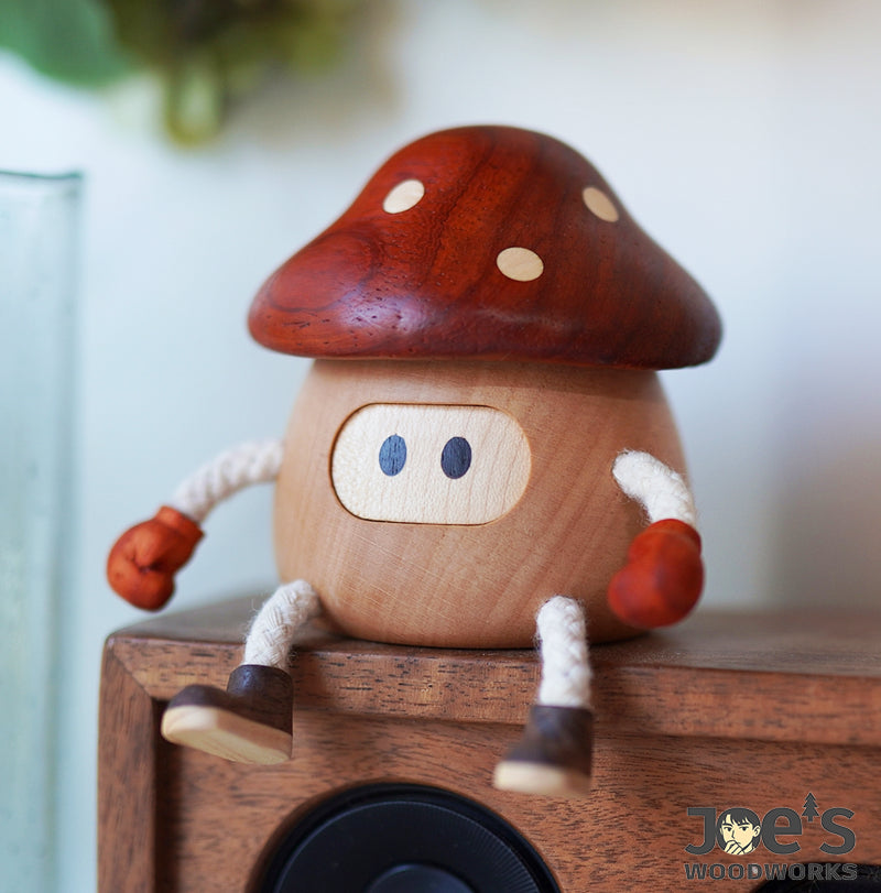Wooden mushroom decor doll sitting on speaker with red boxing gloves