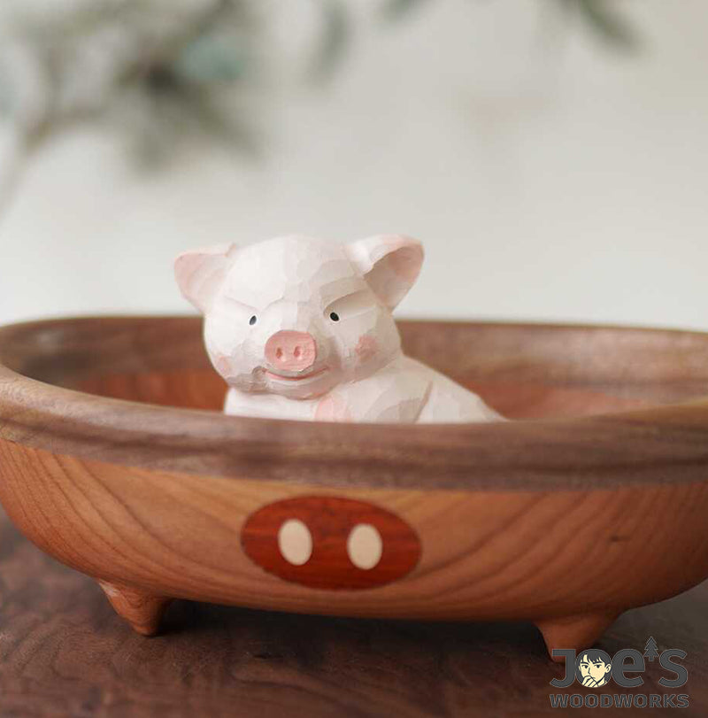 Cute piglet wood figurine sitting inside a wooden bathtub bowl