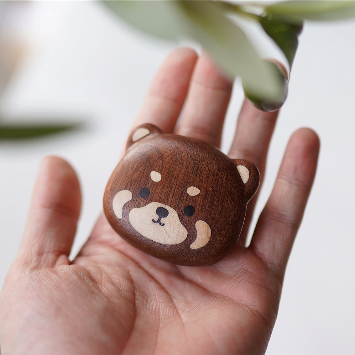 Wooden bear magnet from Pipimu Bear Family resting on palm