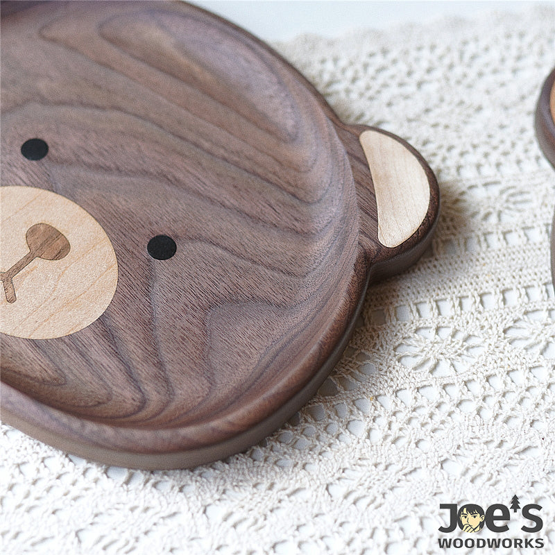 Close-up of Nomi Bear inlaid face detail in maple and ebony wood