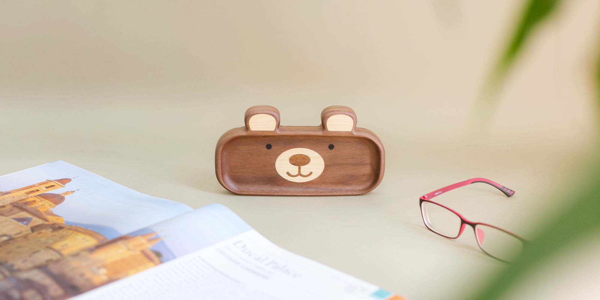 Pipimu wooden bear-shaped glasses box stand up on a surface with glasses and a photo book