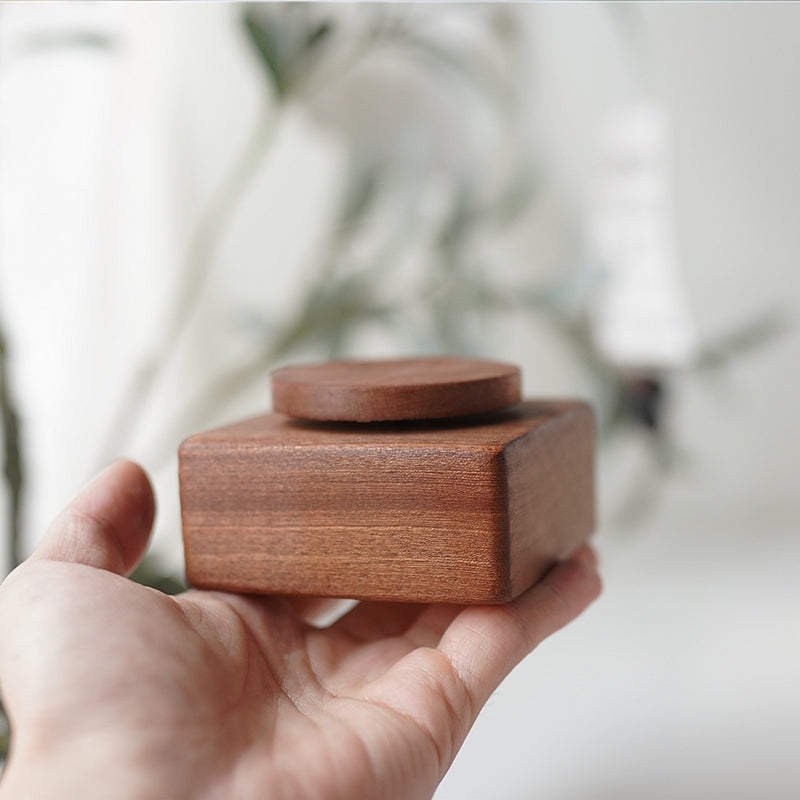 Pipimu ebony wood music box base in hand, compact wooden pedestal for decor
