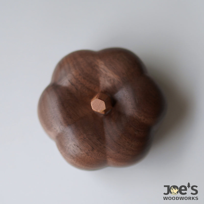 Top-down view of the hand-carved pumpkin box lid with hexagonal wooden stem detail