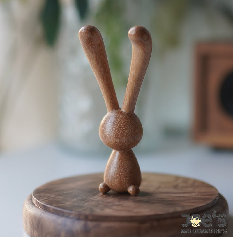 Cute wooden rabbit massage tool sitting on a natural wood stand