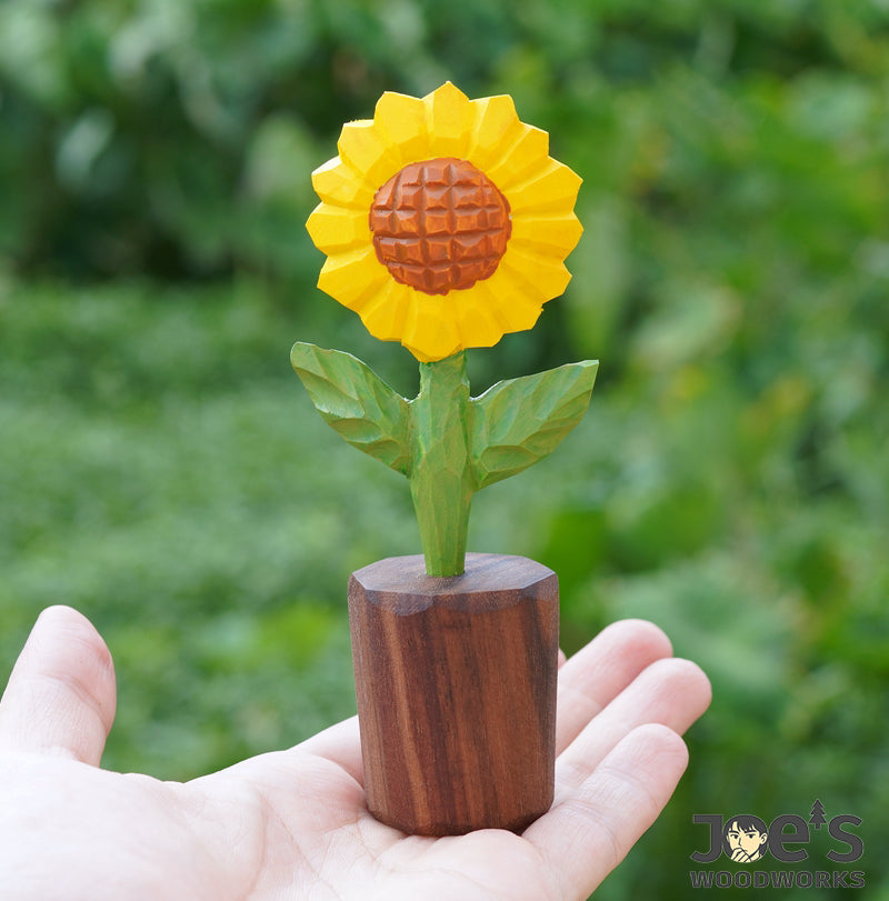 Mini wooden sunflower sculpture held in hand to show size and texture details