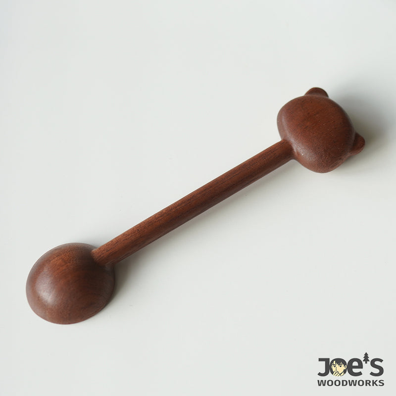 Back view of handcrafted bear scoop, showing solid walnut texture and smooth finish.