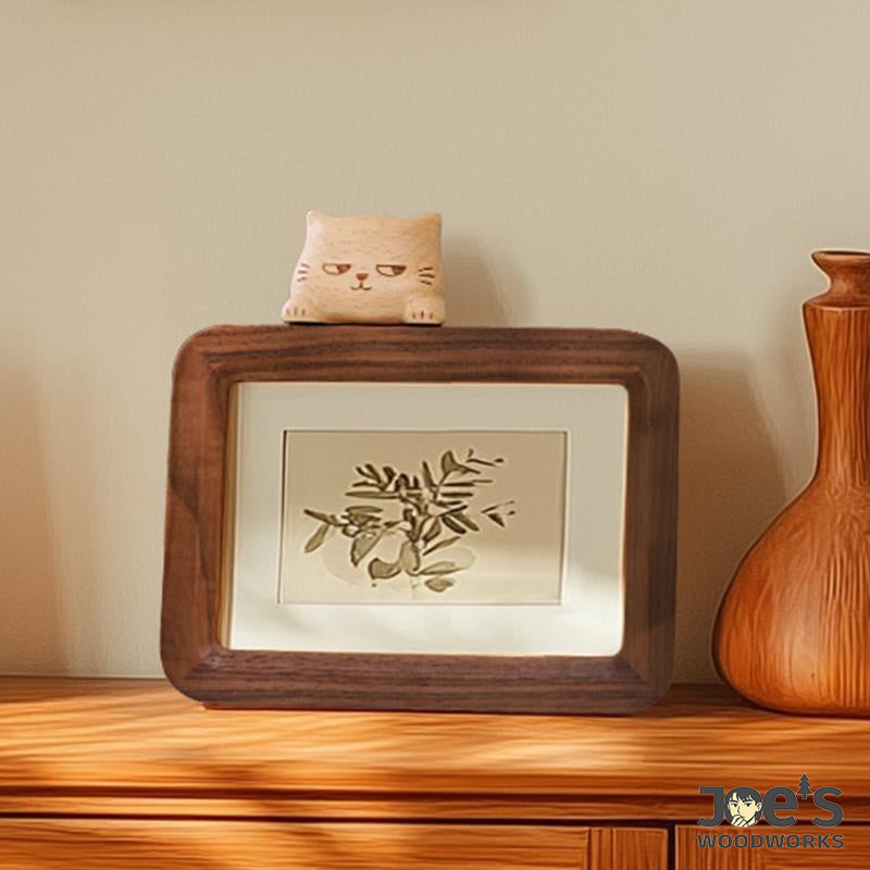 Minimalist wooden frame with carved cat and botanical print display.