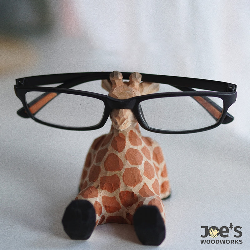 Wooden giraffe sculpture used as eyeglass stand, whimsical home desk decor