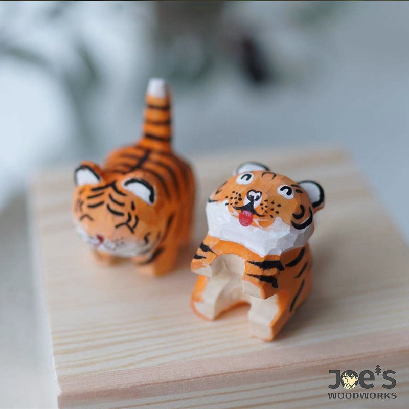 Two wooden tiger figurines in sitting and standing pose, full of handmade charm