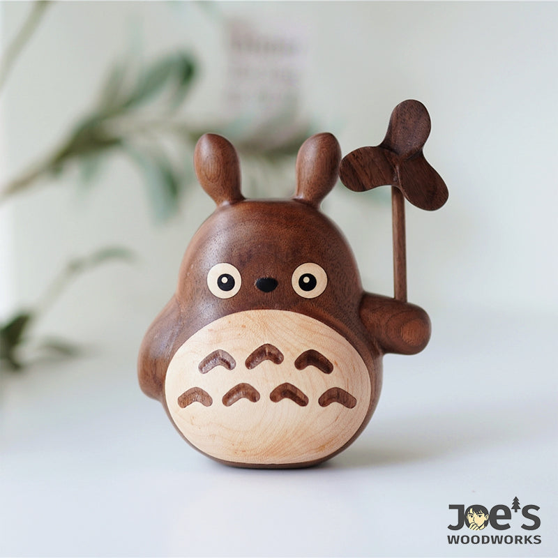 Front view of handcrafted Totoro care cat figure with natural walnut finish and clover windmill.