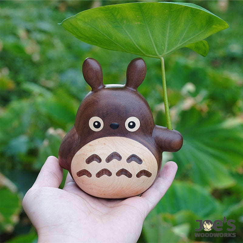 Palm-sized Totoro care cat ornament in solid wood, held in hand for size reference.