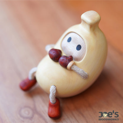 Handmade banana-shaped wooden figurine with red gloves – Joe&