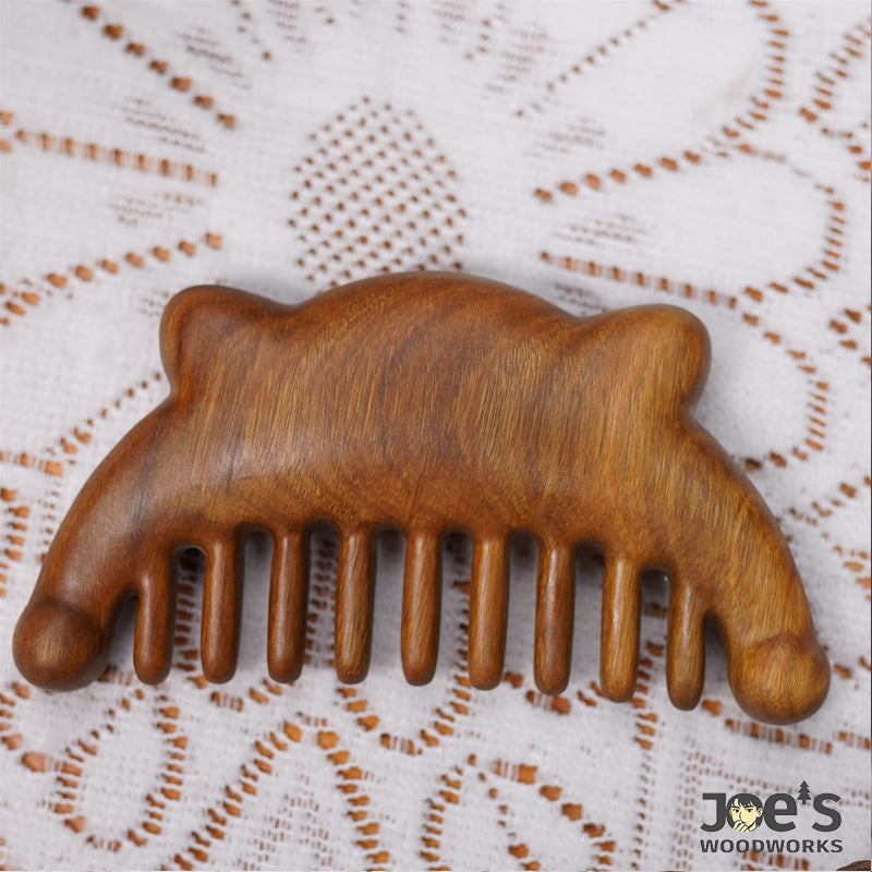 Back side of wooden bear comb showing smooth woodgrain texture
