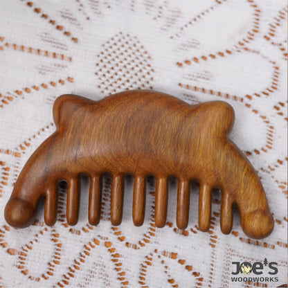 Back side of wooden bear comb showing smooth woodgrain texture