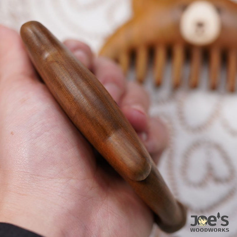 Back side of wooden bear comb showing smooth woodgrain texture