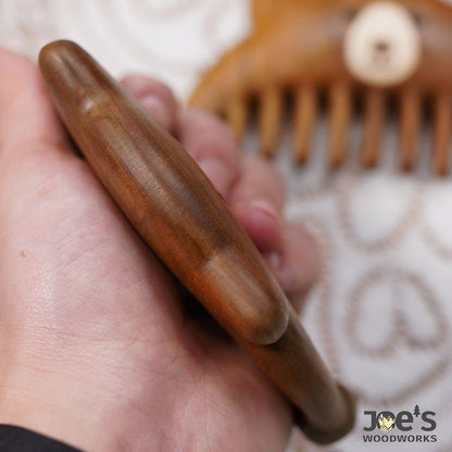Back side of wooden bear comb showing smooth woodgrain texture