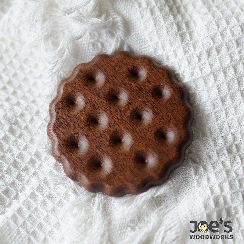 Round cookie-style walnut wood coaster on textured cloth