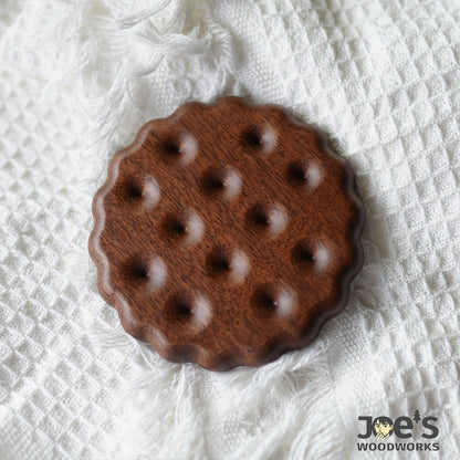 Round cookie-style walnut wood coaster on textured cloth