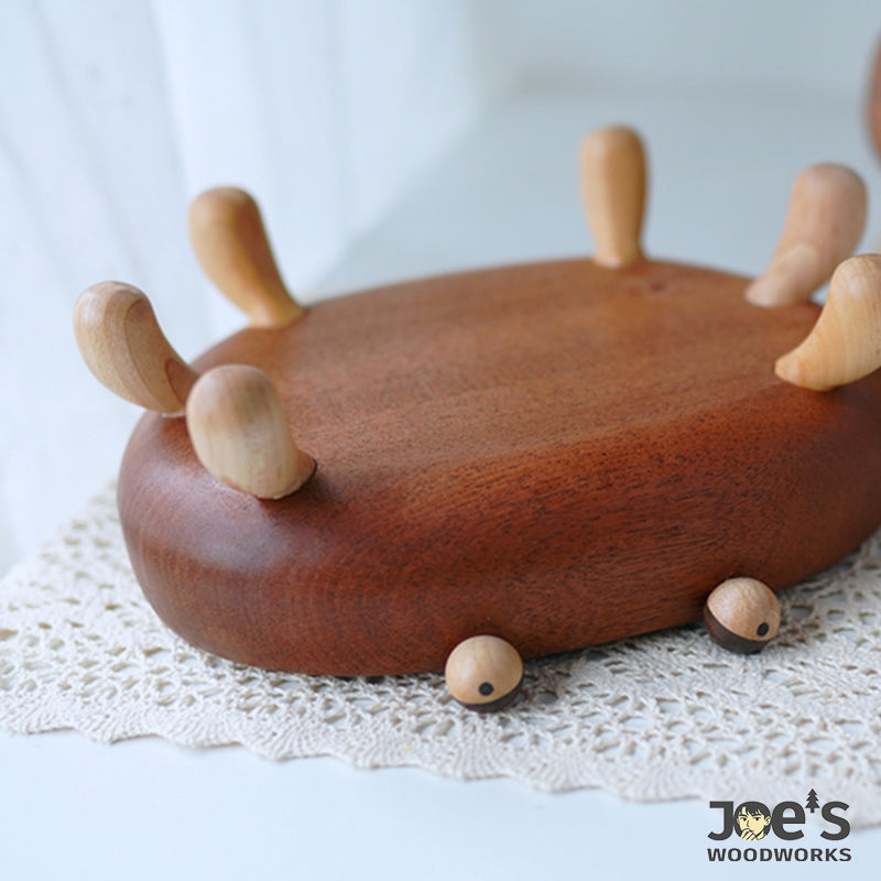 Bottom view of crab wooden tray showing curved legs and cute eye carvings