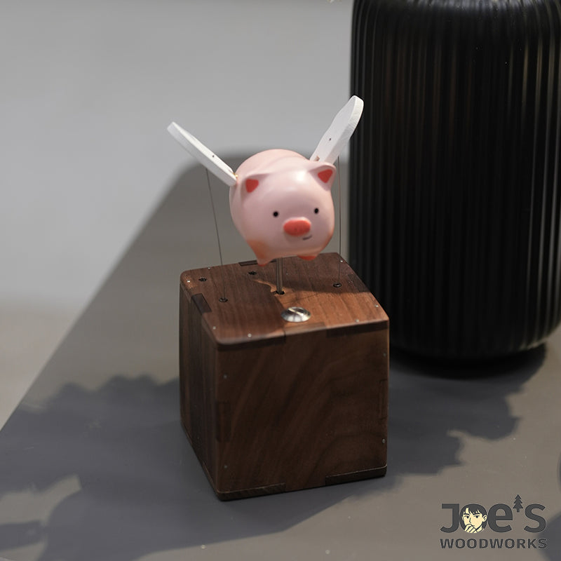 Side view of handmade wooden flying pig automaton flapping wings