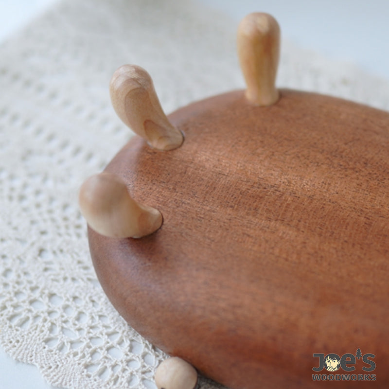 Close-up of hand-carved wooden legs on whimsical crab-shaped bowl