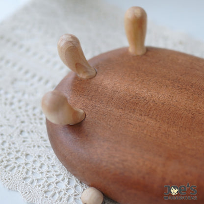 Close-up of hand-carved wooden legs on whimsical crab-shaped bowl