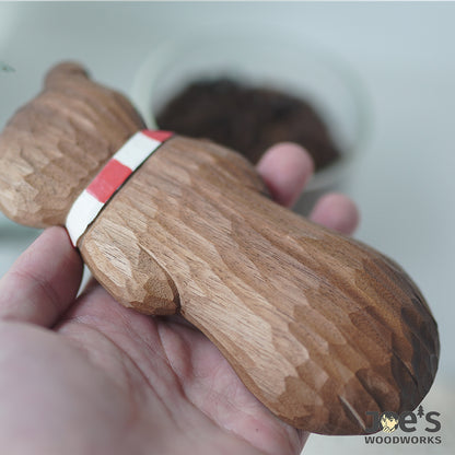 Close-up of hand-carved texture on the back of the wooden bear scoop.