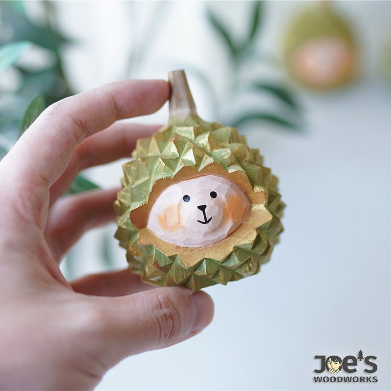 Cute durian-shaped animal wood figurine held in hand