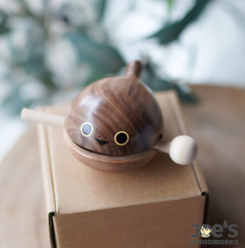 Cute handmade whale knock toy resting on a box – crafted from solid natural wood