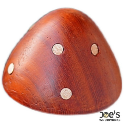 Close-up of red mushroom magnet highlighting wood grain and dot pattern