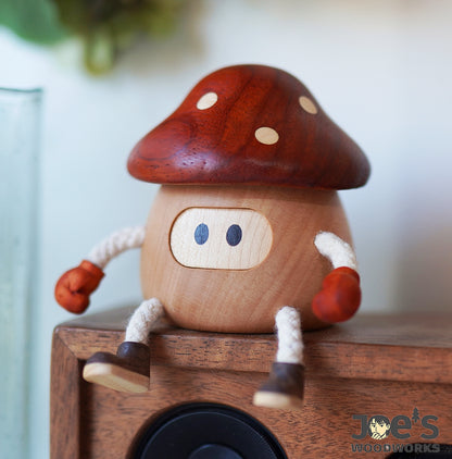 Wooden mushroom decor doll sitting on speaker with red boxing gloves